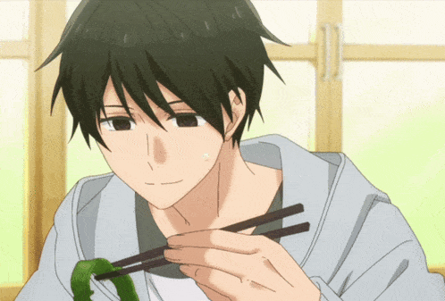 a man is eating something with chopsticks and smiling at the camera