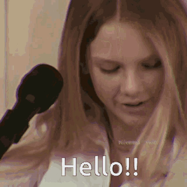 a woman is talking into a microphone and the words hello are visible