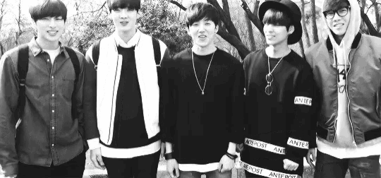 a black and white photo of a group of young men standing next to each other .
