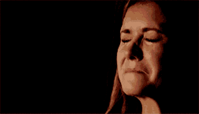 a close up of a woman with her eyes closed and her mouth open