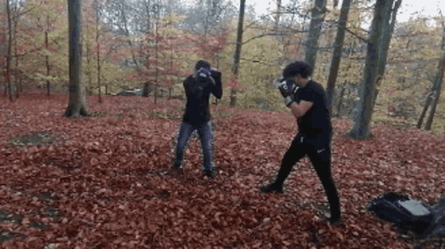 two men are boxing in the woods and one is wearing nike shorts