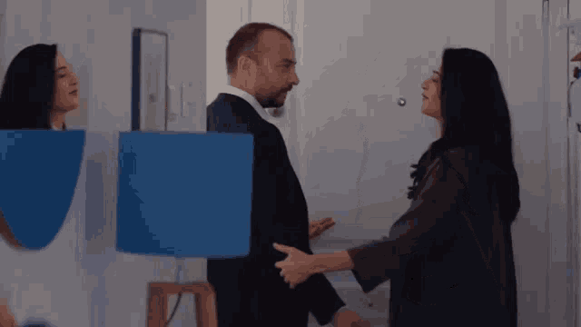 a man and a woman are standing next to each other in a living room .