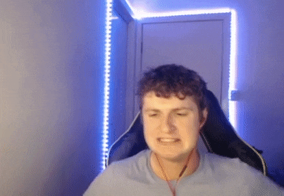 a man is sitting in a gaming chair in front of a blue light .