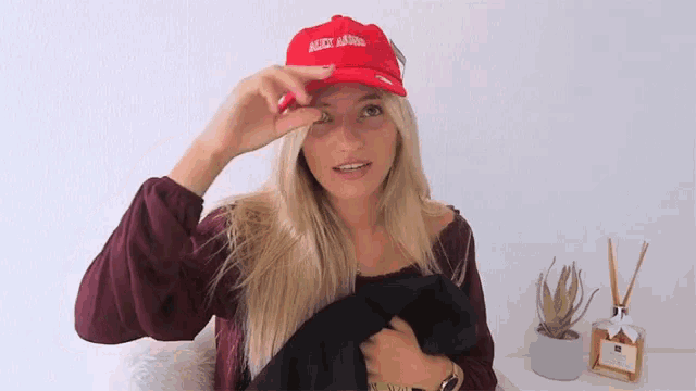 a woman wearing a red hat that says " make america great again " on it