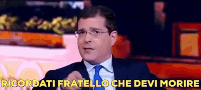 a man in a suit and tie says " ricordati fratello che devi morire " while pointing