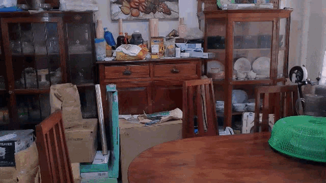 a messy room with a table and chairs including a box that says ' hyundai ' on it