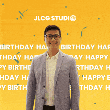 a man in a suit stands in front of a yellow background that says jlcg studio on it