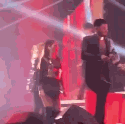 a man and a woman are standing on a stage .