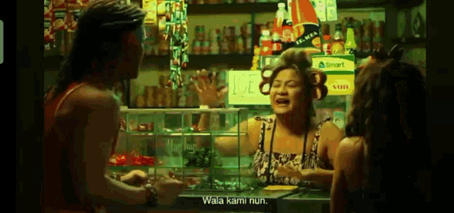 a man and two women are standing in a store talking to a woman behind a counter .