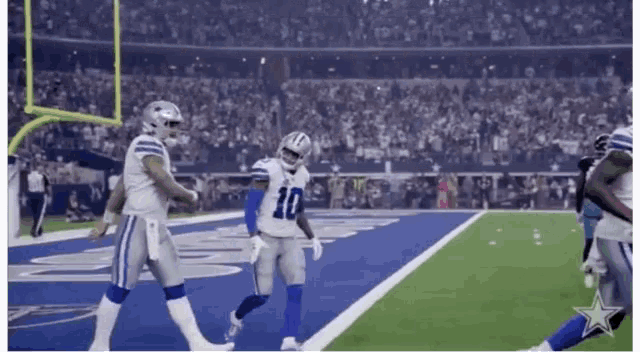 a football player wearing a number 10 jersey is walking on the field .