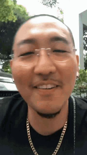 a close up of a man wearing glasses and a chain