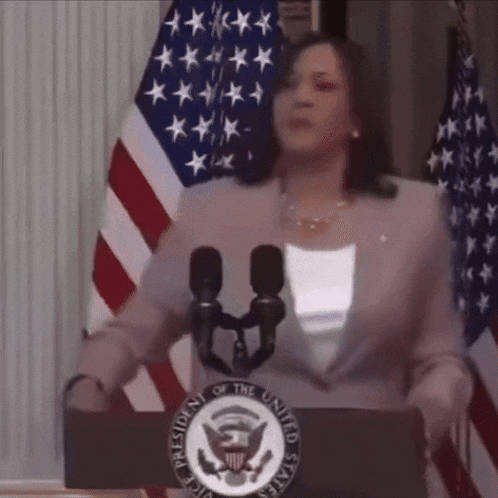a woman stands at a podium with the president of the united states seal on it