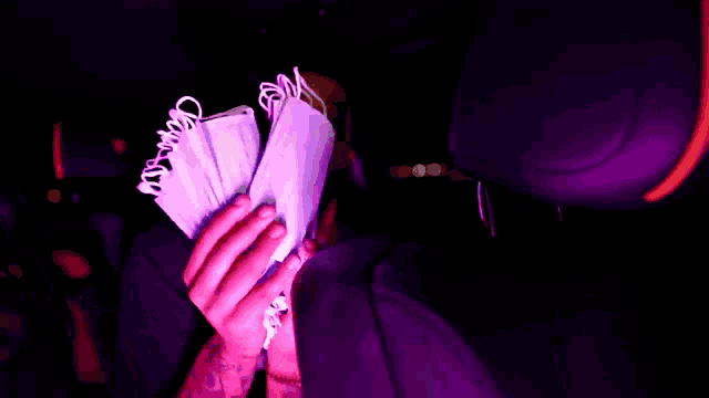 a person is holding a bunch of money in their hand