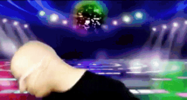 a bald man is standing in front of a disco ball on a stage