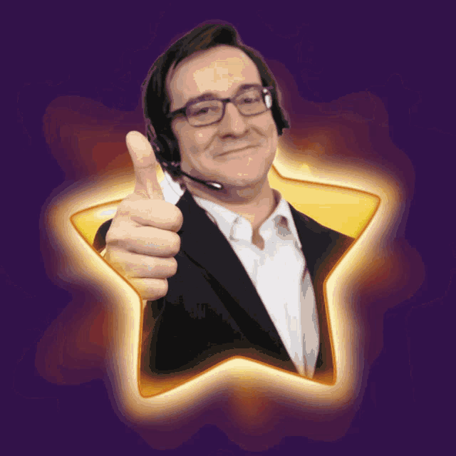 a man wearing glasses and a headset gives a thumbs up