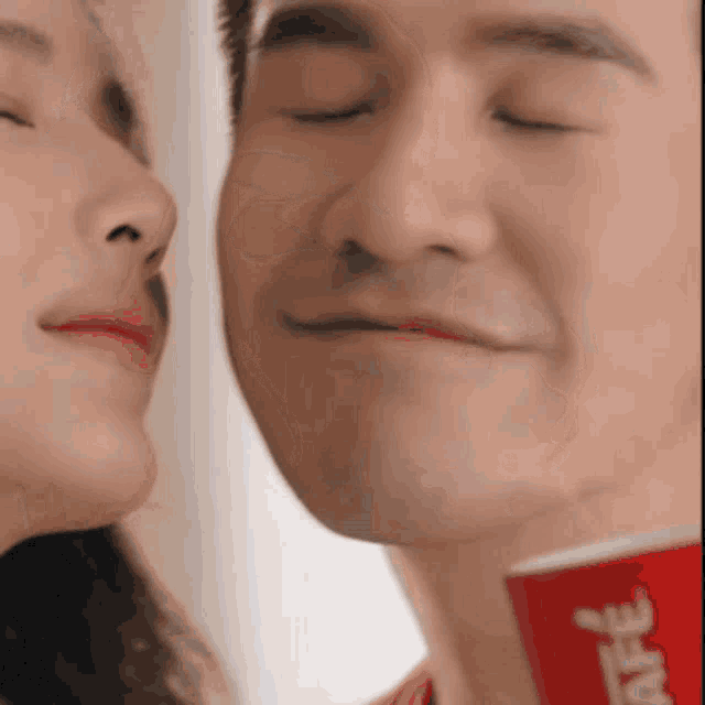 a close up of a man 's face with a cup of nescafe in front of him