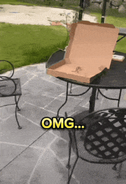 a pizza box sits on a table with the word omg written in yellow