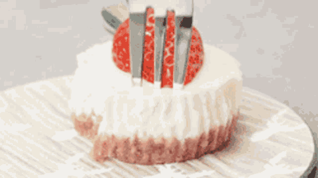 a piece of cheesecake with a strawberry on top and a fork on it