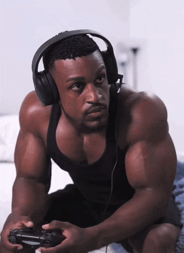 a muscular man wearing headphones and holding a game controller