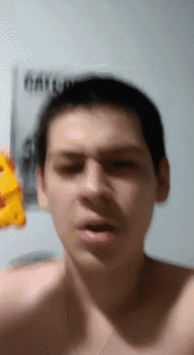 a man without a shirt is holding a piece of cheese in his hand