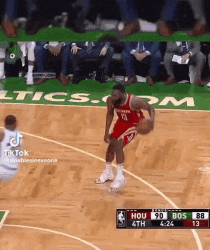 a basketball player in a red jersey is dribbling the ball on a basketball court .