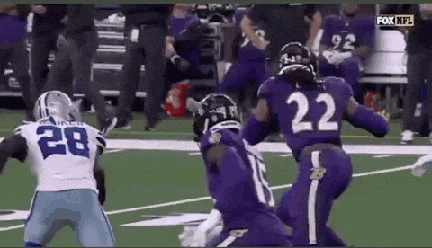 a group of football players in purple uniforms are playing on a field .