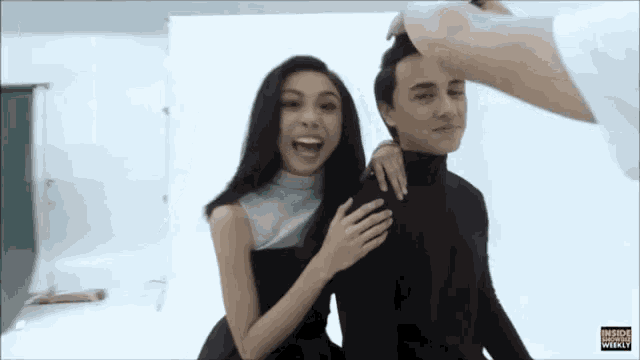 a man and a woman are posing for a picture and the woman is laughing .