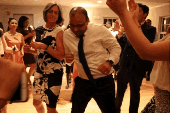 a man in a suit and tie is dancing with a woman in a dress