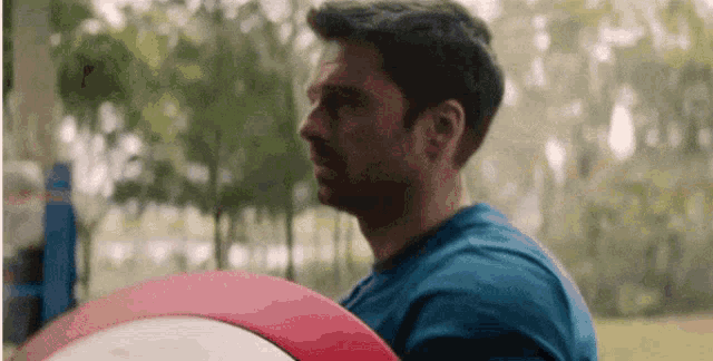 a man is holding a red and white shield in his hand .