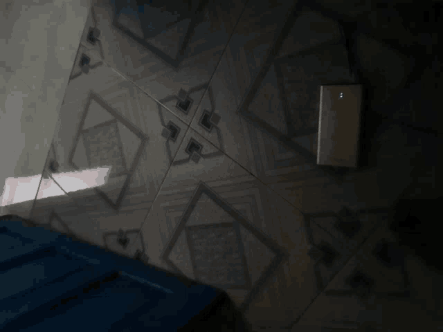 a power bank is sitting on a tiled floor next to a blue door