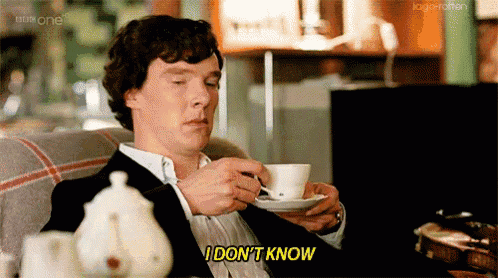 a man is sitting on a couch drinking a cup of coffee and saying i don 't know
