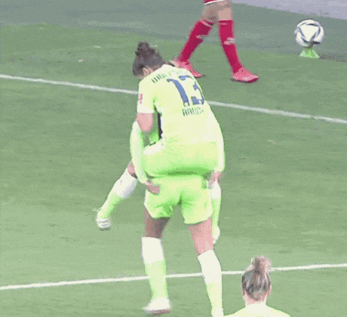 a soccer player wearing a number 15 jersey is carrying another player on her shoulders