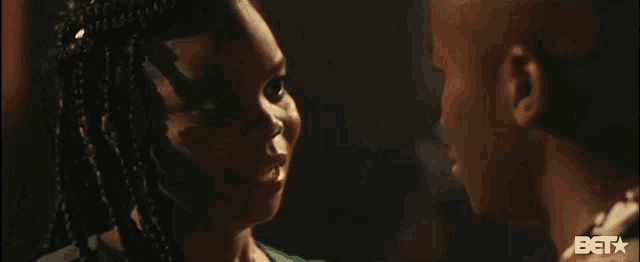 a man and a woman are looking into each other 's eyes in a dark room .