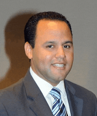 a man wearing a suit and tie is smiling for the camera