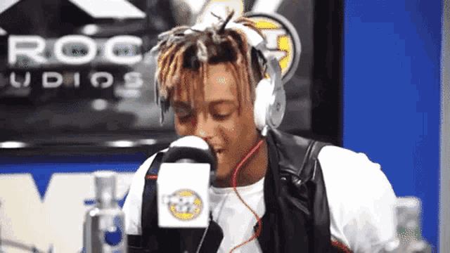 a man wearing headphones is talking into a microphone in a radio station .