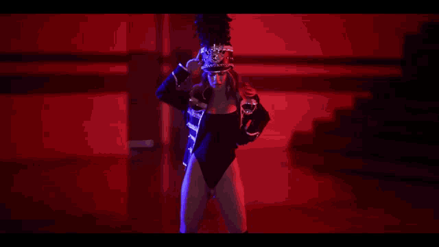 a woman in a black leotard and hat is dancing in a dark room