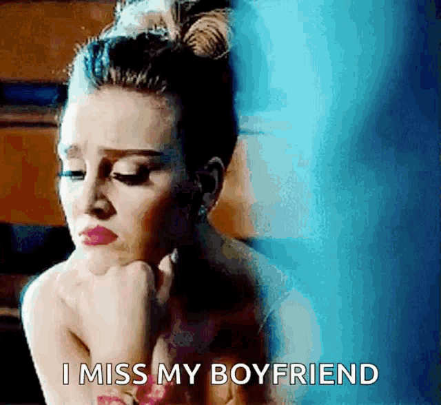 a woman is sitting with her hand on her chin and says i miss my boyfriend