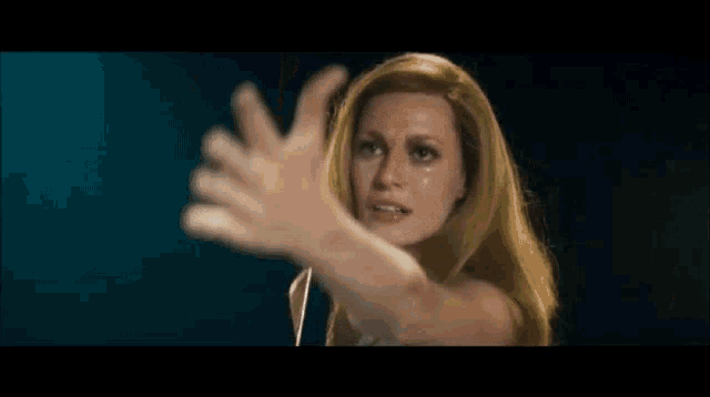 a woman with long blonde hair is giving a thumbs up and says you hear me ?