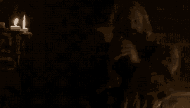 a man with a beard is standing next to a woman in a dark room .