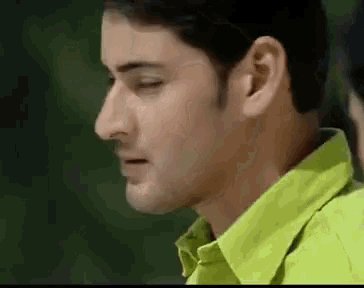 a close up of a man 's face in a green shirt .