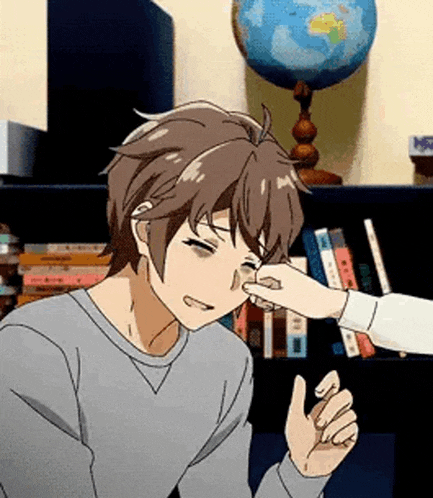 a person is touching a man 's nose with their hand .