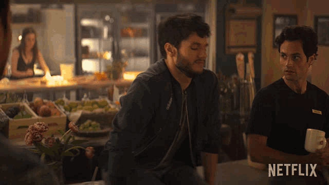 two men sitting at a table with a netflix logo on the bottom