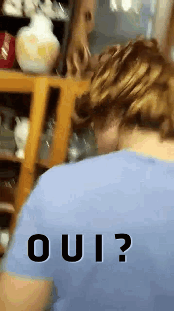 a person in a blue shirt with the word oui written on the back