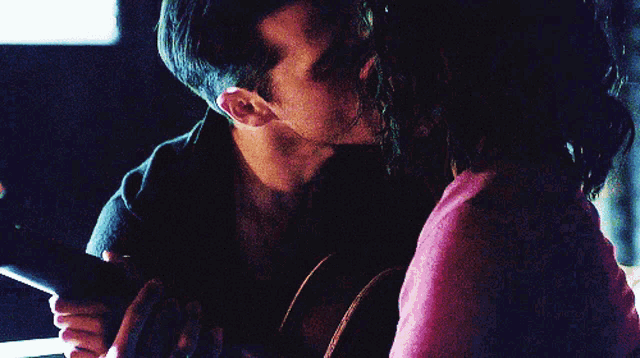 a man kissing a woman on the cheek in a dark room