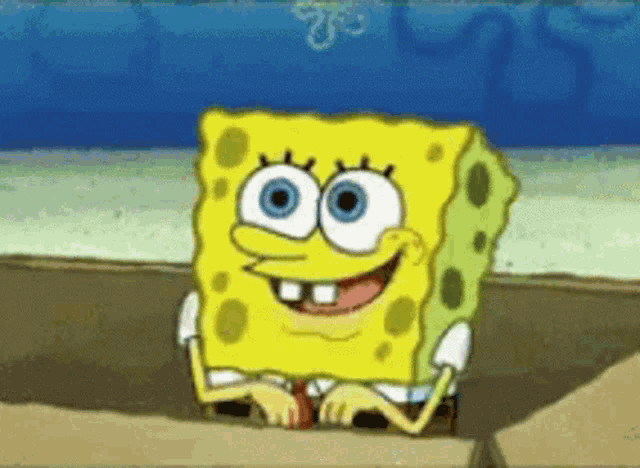 spongebob squarepants is smiling while sitting on a rock in the sand .