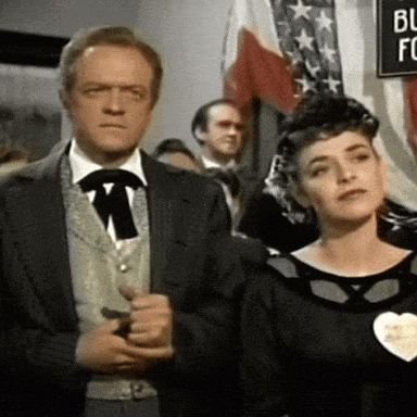 a man and a woman are standing in front of a sign that says bl