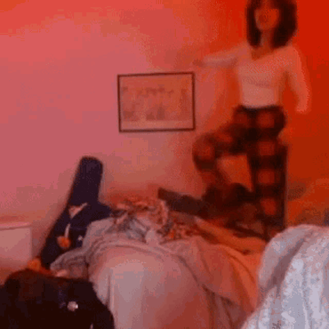 a woman standing on a chair in a bedroom
