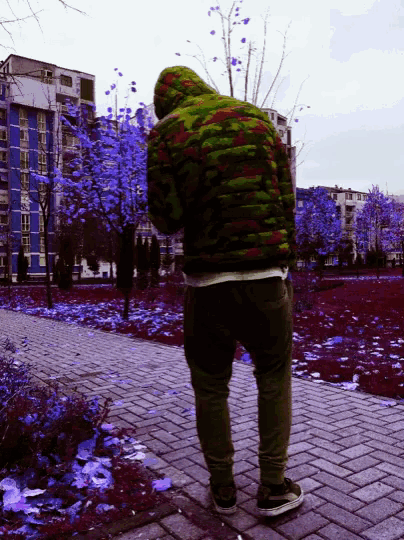 a man in a colorful jacket is standing on a sidewalk