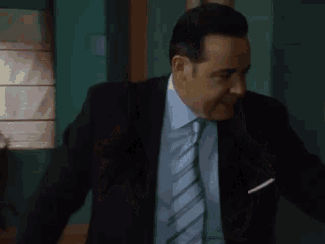 a man in a suit and tie stands in a doorway