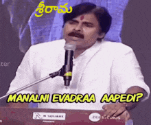 a man is giving a speech in front of a microphone in a telugu language .